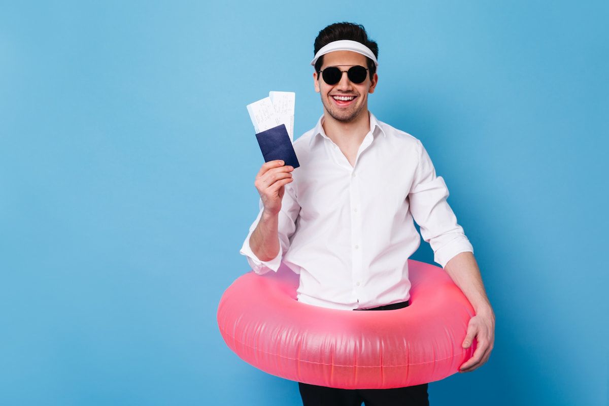 4 sfaturi calatorie maldive - un barbat in tinuta business cu un colac de plaja si un pasaport in mana